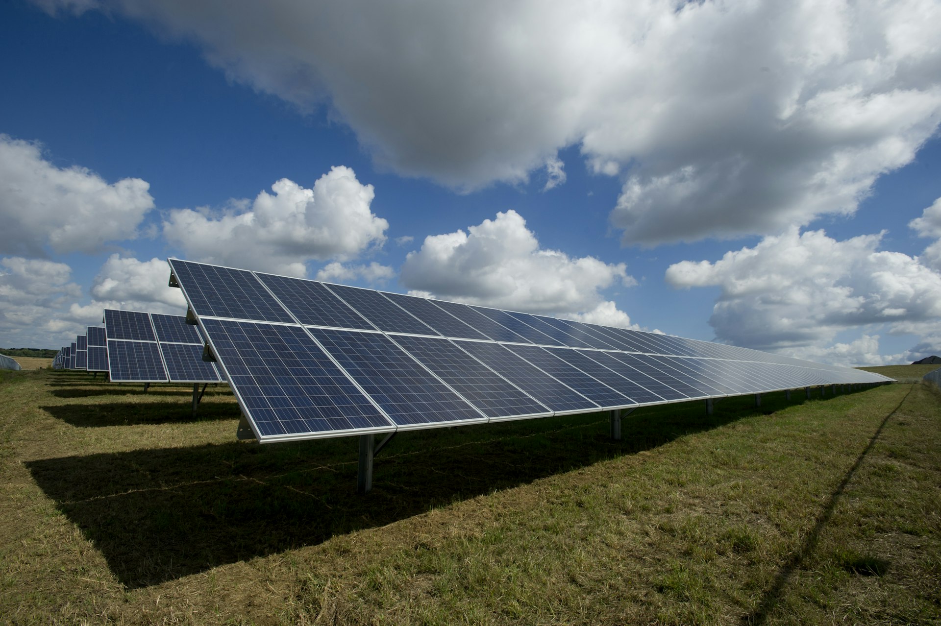 Solar panels in an open field with mountains in the background